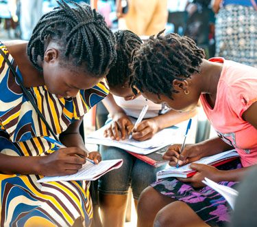 Eine Bibellesegruppe in Mosambik ist konzentriert über das Bibel Liga-Material gebeugt