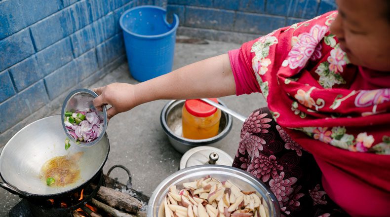 Dhan Maya, Surithangs Frau, kocht im Freien mit Holz. Meistens gibt es Dal Bhat (Reis mit Linsen und Gemüse).