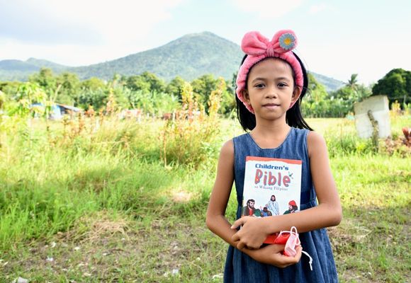 Aliana von den Philippinen mit ihrer Kinderbibel in der Hand 