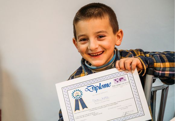 Ein stolzer Teilnehmer am Programm Philippus-Junior zeigt sein Zertifikat.